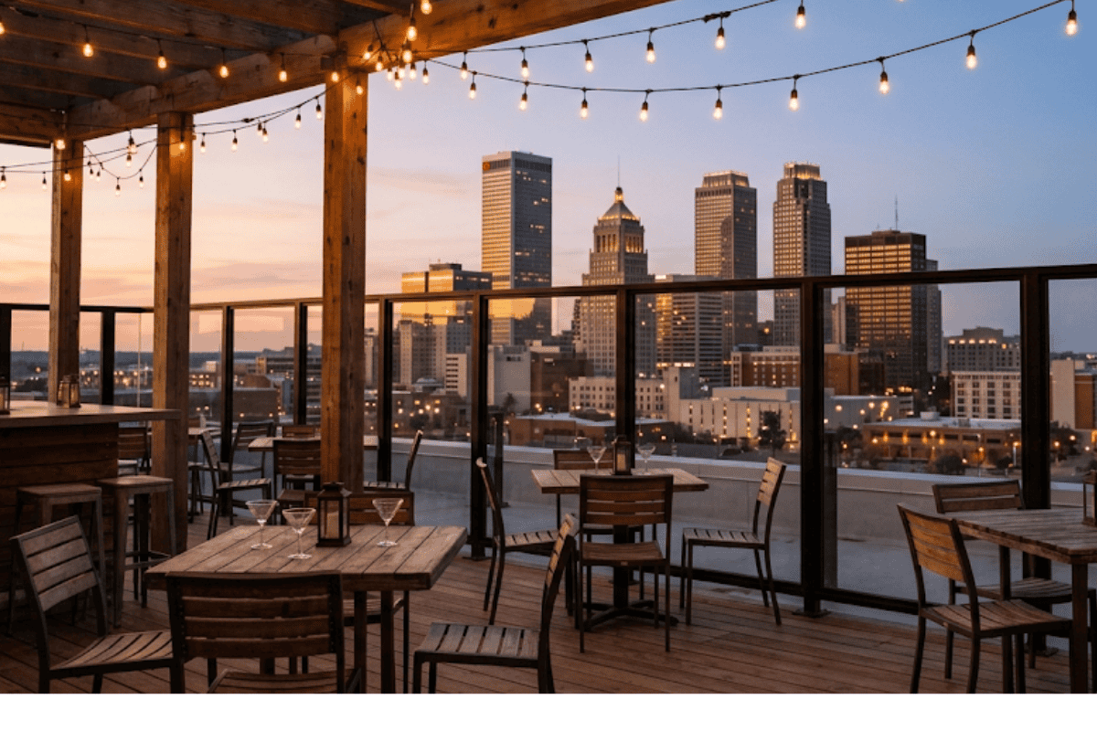 Rooftop patio tables facing the downtown Tulsa skyline at sunset near BOK Center